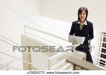 Portrait of a businesswoman using a laptop and smiling View Large Photo Image Stock Image - Portrait of a businesswoman using a laptop and smiling. Fotosearch