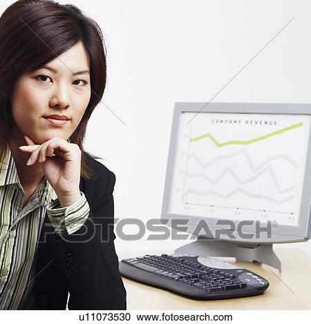 Stock Image - Portrait of a businesswoman with a progress report in the background. Fotosearch