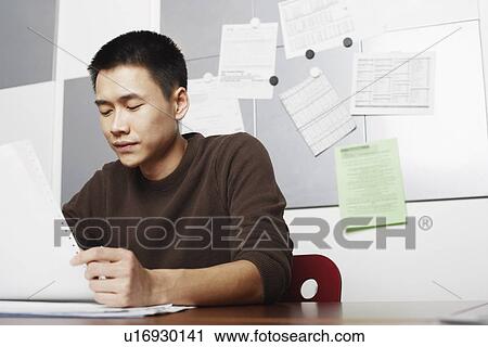 Stock Image - Businessman holding a printout. Fotosearch