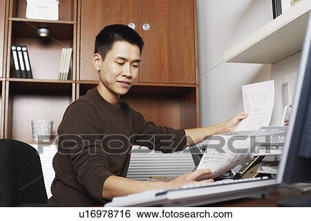 Stock Photograph - Businessman holding a printout. Fotosearch