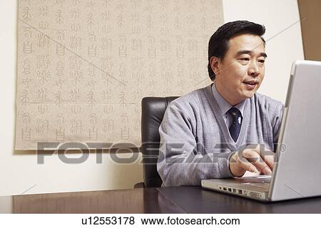 Businessman using a laptop View Large Photo Image Stock Photo - Businessman using a laptop. Fotosearch