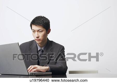 Stock Image - Close-up of a businessman using a laptop. Fotosearch