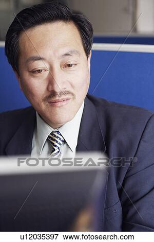 Stock Photo - Close-up of a businessman using a computer. Fotosearch