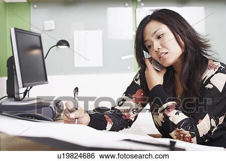 Close-up of a businesswoman using a mobile phone writing with a pen View Large Photo Image Stock Photograph - Close-up of a businesswoman using a mobile phone writing with a pen. Fotosearch