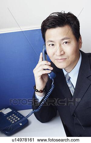 Stock Image - Portrait of a businessman talking on the telephone. Fotosearch