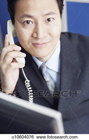 Stock Photograph - Portrait of a businessman talking on the telephone. Fotosearch