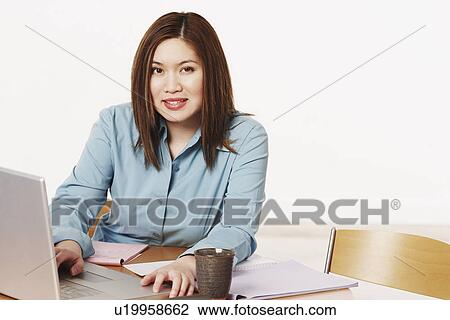 Stock Image - Portrait of a businesswoman using a laptop. Fotosearch