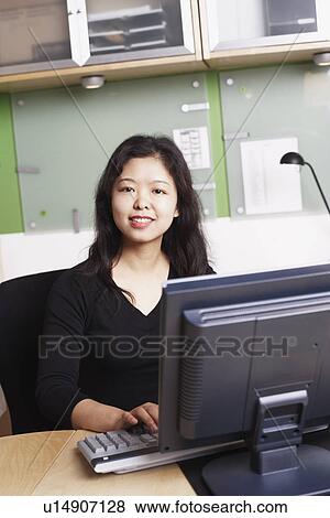Stock Photo - Portrait of a businesswoman using a computer smiling. Fotosearch