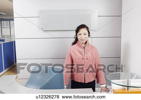 Stock Photo - Portrait of a customer service representative standing in an office. Fotosearch