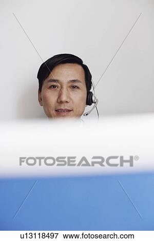 Portrait of a customer service representative behind a cubicle View Large Photo Image Stock Photo - Portrait of a customer service representative behind a cubicle. Fotosearch