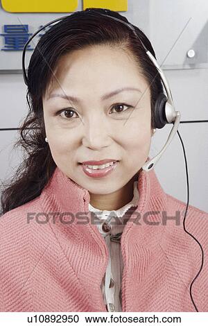 Stock Image - Portrait of a mature woman wearing a headset. Fotosearch
