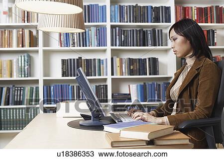 Stock Image - Side profile of a businesswoman using a computer. Fotosearch