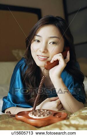 Stock Image - Close-up of a young woman talking on the telephone. Fotosearch