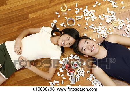 High angle view of a young couple lying on the floor and smiling View Large Photo Image Stock Photo - High angle view of a young couple lying on the floor and smiling. Fotosearch