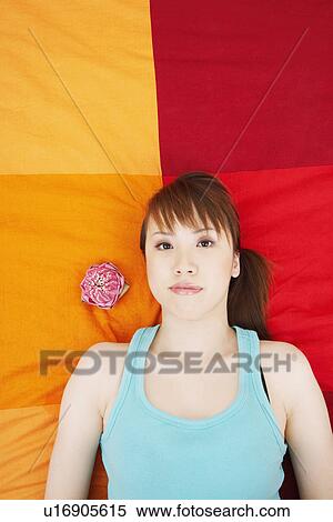 Stock Photography - Portrait of a young woman lying on the bed. Fotosearch