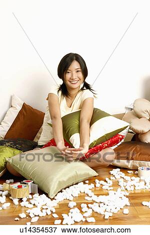 Portrait of a young woman sitting on the floor and smiling View Large Photo Image Stock Photo - Portrait of a young woman sitting on the floor and smiling. Fotosearch