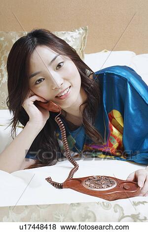 Portrait of a young woman talking on the telephone View Large Photo Image Stock Photo - Portrait of a young woman talking on the telephone. Fotosearch