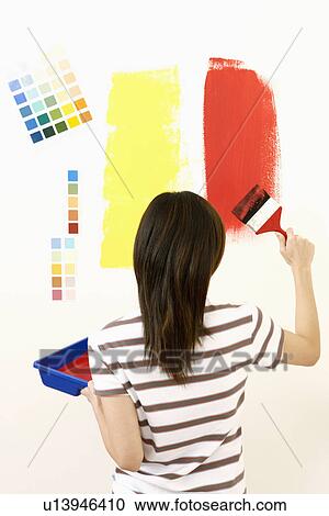 Rear view of a young woman painting the wall with a paintbrush View Large Photo Image Stock Image - Rear view of a young woman painting the wall with a paintbrush. Fotosearch