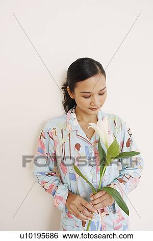 Stock Photograph - Young woman holding a flower. Fotosearch