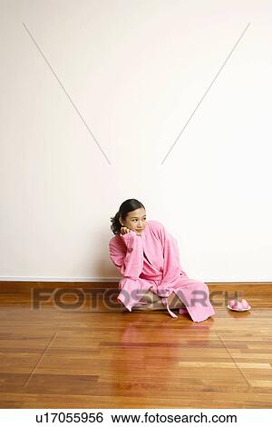 Young woman sitting on a hardwood floor View Large Photo Image Stock Photograph - Young woman sitting on a hardwood floor. Fotosearch