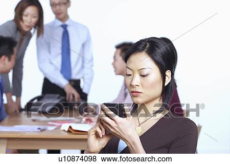 Stock Photo - Businesswoman holding a personal data assistant. Fotosearch
