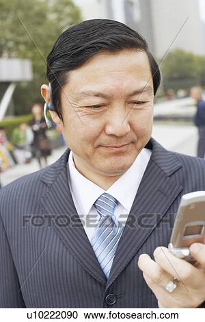 Stock Image - Close-up of a businessman using a mobile phone. Fotosearch