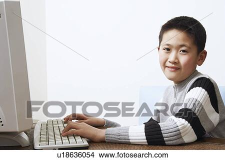 Portrait of a boy using a computer View Large Photo Image Picture - Portrait of a boy using a computer. Fotosearch
