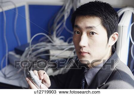 Portrait of a businessman holding a mobile phone View Large Photo Image Stock Image - Portrait of a businessman holding a mobile phone. Fotosearch