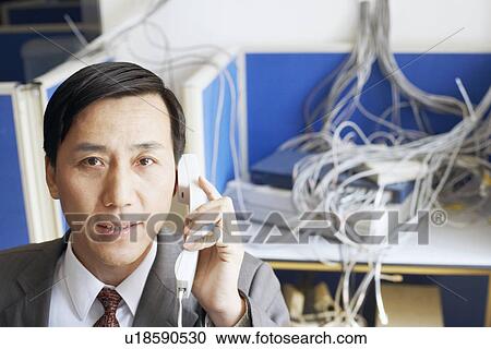 Portrait of a businessman using a telephone in a server room View Large Photo Image Stock Image - Portrait of a businessman using a telephone in a server room. Fotosearch
