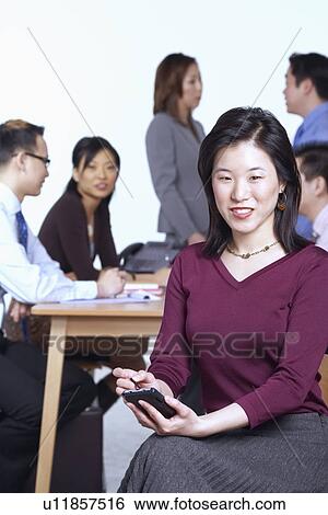 Stock Photograph - Portrait of a businesswoman holding a personal data assistant. Fotosearch