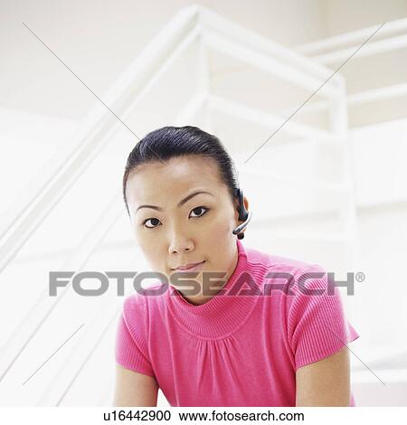 Stock Image - Portrait of a businesswoman sitting on a staircase and holding a mobile phone. Fotosearch