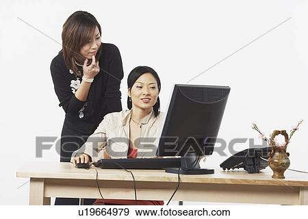Stock Photo - Two businesswomen looking at a computer. Fotosearch