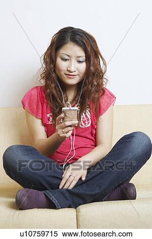 Stock Photography - Young woman listening to music. Fotosearch
