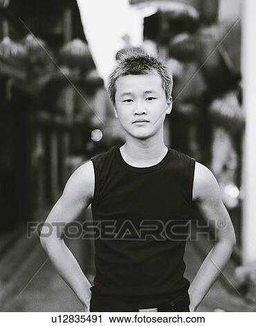 Stock Image - Portrait of a boy standing with his hands on his hips. Fotosearch