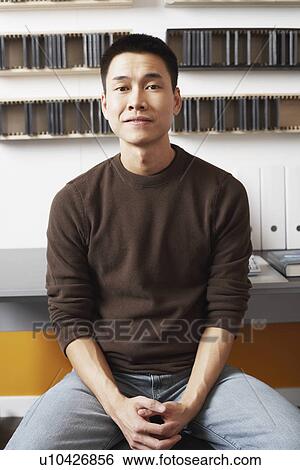 Stock Photograph - Portrait of a businessman sitting. Fotosearch