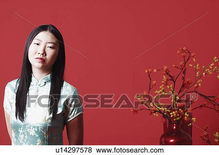 Portrait of a young woman standing near a flower pot View Large Photo Image Stock Photo - Portrait of a young woman standing near a flower pot. Fotosearch