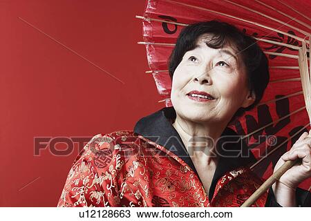 Close-up of a mature woman holding a parasol View Large Photo Image Stock Image - Close-up of a mature woman holding a parasol. Fotosearch