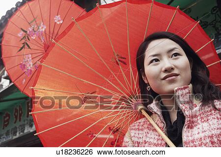 Close-up of a young woman under a parasol View Large Photo Image Stock Photograph - Close-up of a young woman under a parasol. Fotosearch
