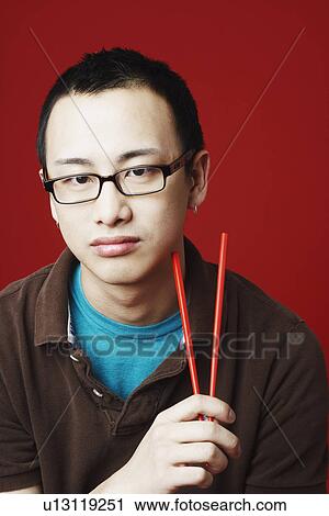 Portrait of a young man holding chopsticks View Large Photo Image Stock Image - Portrait of a young man holding chopsticks. Fotosearch