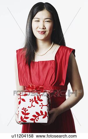 Stock Photo - Portrait of a young woman holding a gift. Fotosearch