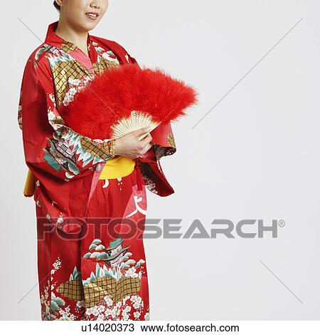 Portrait of a young woman holding a folding fan View Large Photo Image Stock Image - Portrait of a young woman holding a folding fan. Fotosearch