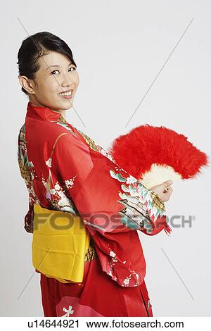 Portrait of a young woman holding a feather fan View Large Photo Image Stock Image - Portrait of a young woman holding a feather fan. Fotosearch