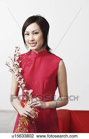 Portrait of a young woman holding flowers View Large Photo Image Stock Image - Portrait of a young woman holding flowers. Fotosearch