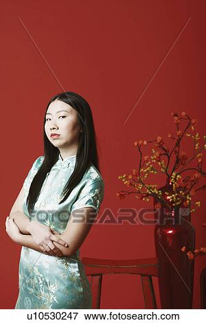 Portrait of a young woman standing near a flower pot View Large Photo Image Stock Photo - Portrait of a young woman standing near a flower pot. Fotosearch