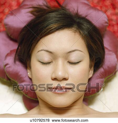 High angle view of a young woman lying on the floor with her eyes closed View Large Photo Image Stock Photo - High angle view of a young woman lying on the floor with her eyes closed. Fotosearch