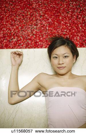 High angle view of a young woman lying on the floor near a hot tub filled with rose petals View Large Photo Image Stock Photo - High angle view of a young woman lying on the floor near a hot tub filled with rose petals. Fotosearch