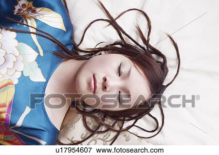 High angle view of a young woman with her eyes closed View Large Photo Image Stock Photo - High angle view of a young woman with her eyes closed. Fotosearch