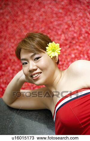 Portrait of a young woman lying on floor near a hot tub filled with rose petals View Large Photo Image Stock Image - Portrait of a young woman lying on floor near a hot tub filled with rose petals. Fotosearch