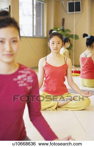 Stock Photograph - Three young women sitting in the lotus position. Fotosearch