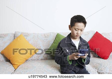 Close-up of a boy playing a video game View Large Photo Image Stock Image - Close-up of a boy playing a video game. Fotosearch
